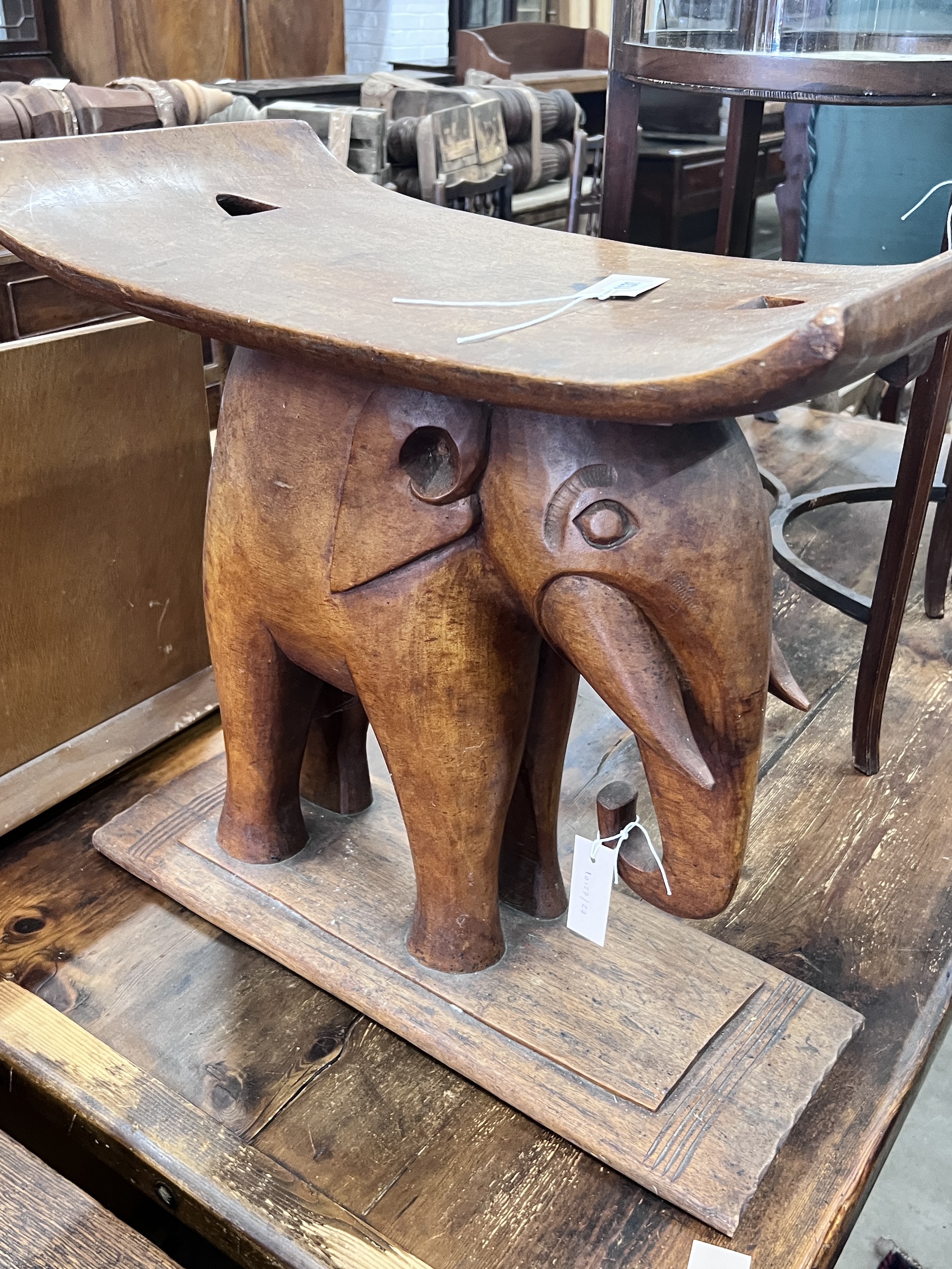 An African Ashanti style carved hardwood elephant stool, width 59cm, depth 32cm, height 58cm